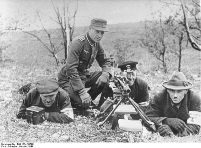 Un veterano sargento instructor enseñando el uso de una MG-42 a tres miembros del Volkssturm