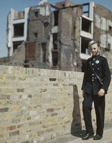 Un joven cartero camina por otra de las zonas devastadas de la capital británica durante los bombardeos