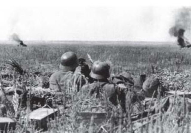 Infantería alemana observando a unos tanques soviéticos puestos fuera de combate por los Flak de 88 mm.